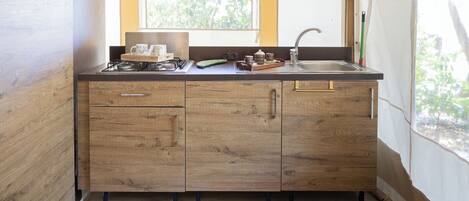 Eine Holz-Küche mit Fenster, Spüle und Schränken.