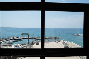 Un puerto deportivo con barcos amarrados, un muelle con asientos y una vista despejada del mar.