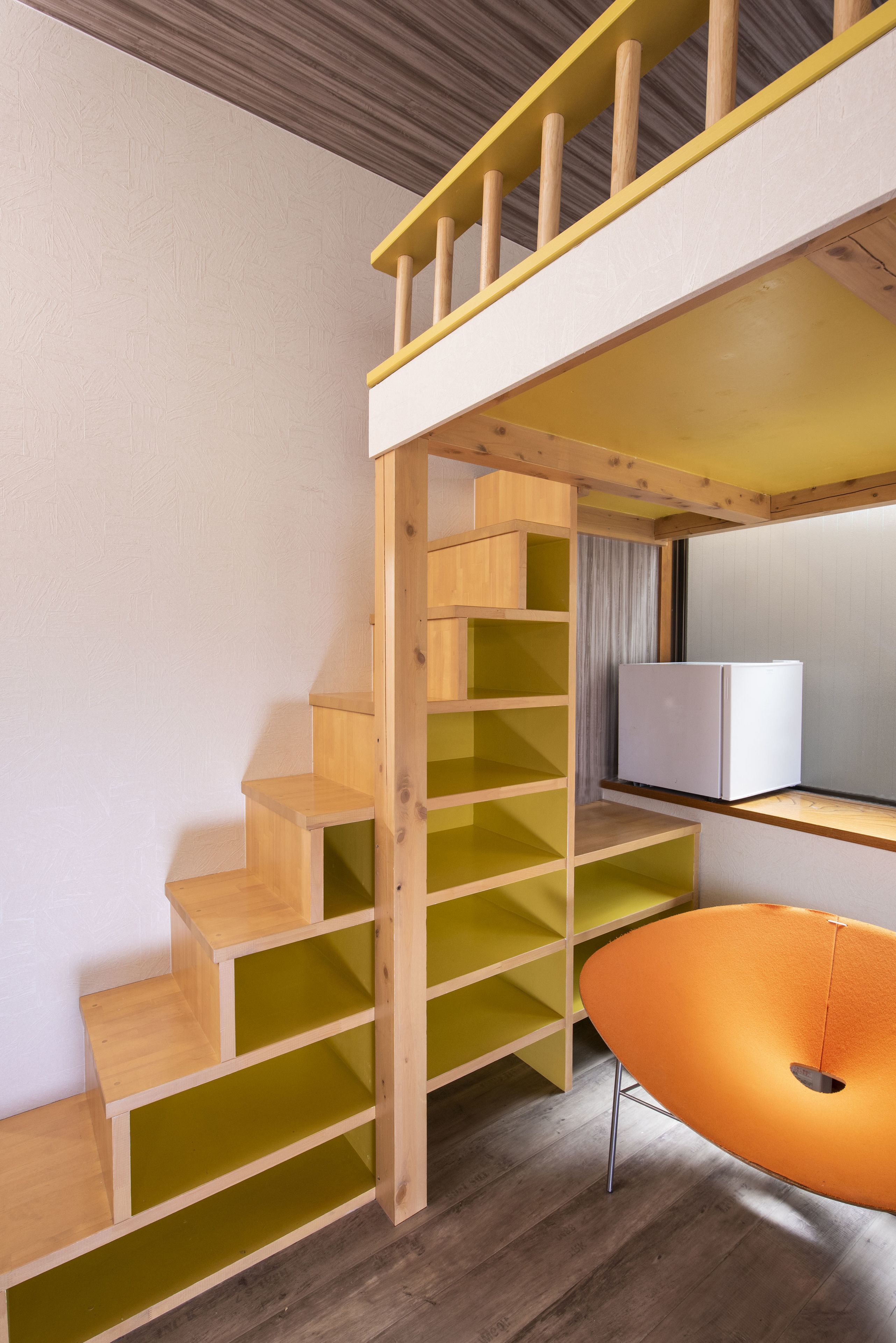 A multi-level wooden staircase with green and yellow steps leading to a lower level.