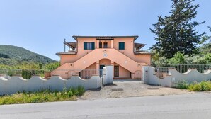 Une maison à deux étages, dotée d’un toit en pente et d’une entrée centrale.