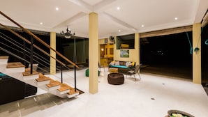 Un salón amplio con una escalera, un sofá y una mesa de centro.