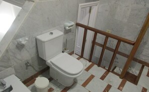 Een bad/douchecombinatie, een haardroger, een bidet, handdoeken