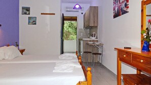 A bedroom with a bed, a desk, and a kitchenette. - Villa Anneta (Corfu)