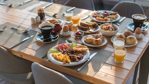 A breakfast table with various dishes, including eggs, toast, and fruit, and a cup of coffee. - B4B Athens 365 Hotel (Kallithea)