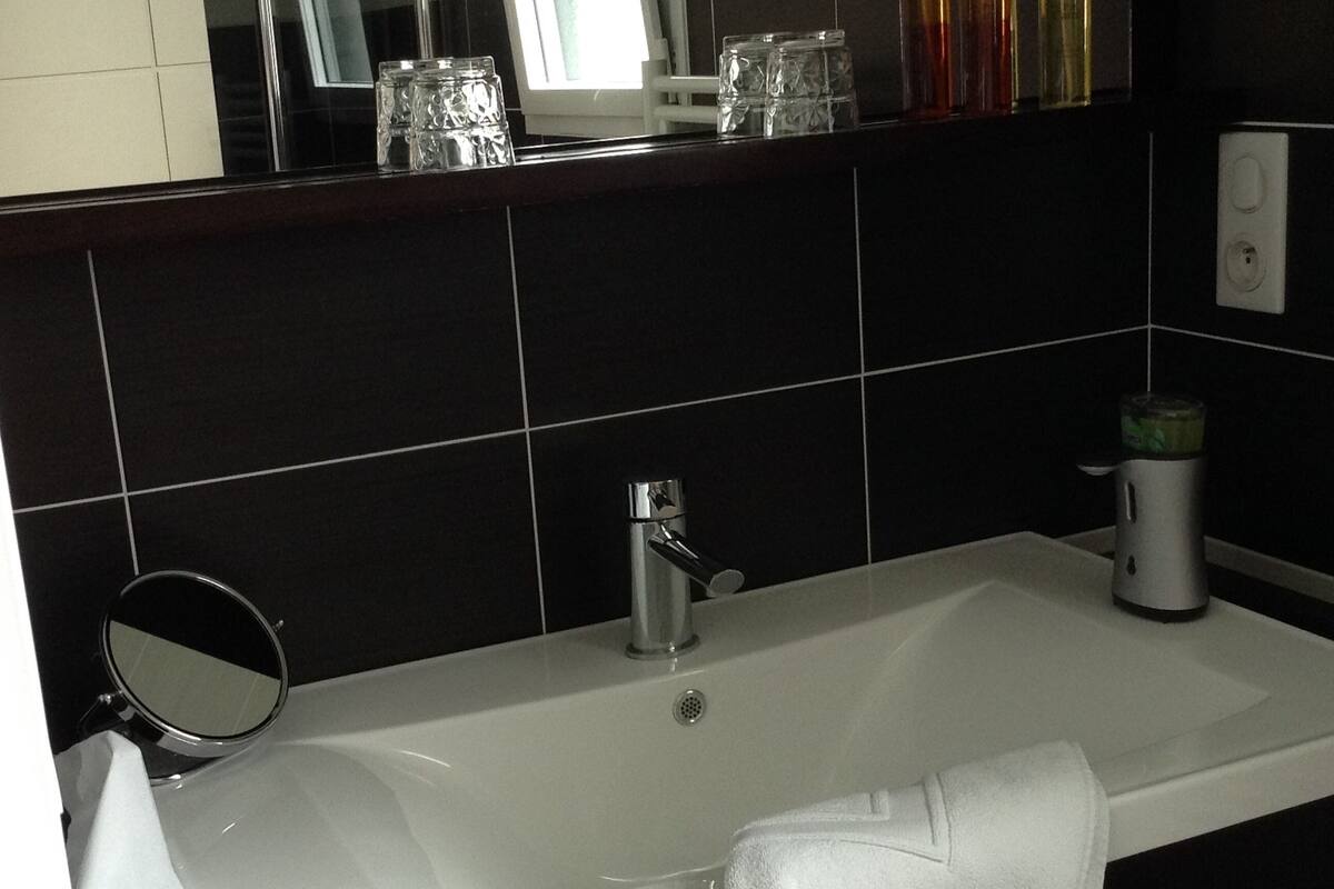 A bathroom with a white sink, a mirror, and a towel rack.