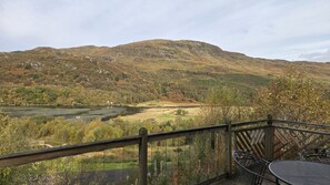 A scenic view from a balcony overlooking a lake and mountains. - Kingfisher a beautiful 5 star, 2 bedroom, 2 bathroom holiday property that can sleep up to 4 people (Crianlarich)