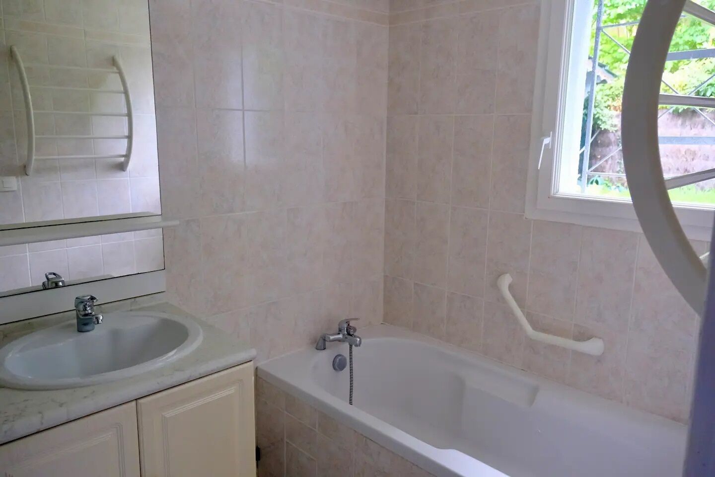 Ein Badezimmer mit Waschbecken, Spiegel und Badewanne.