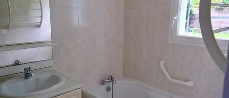 Ein Badezimmer mit Waschbecken, Spiegel und Badewanne.
