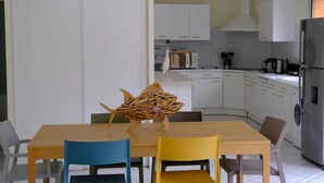 Una cocina moderna con gabinetes blancos, horno integrado y refrigerador de acero inoxidable.