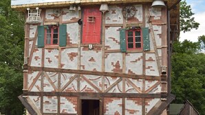 A multi-story building with exposed wooden beams and brickwork.