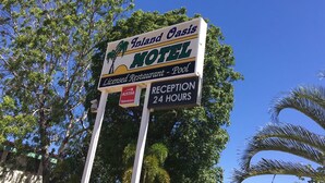 A sign for the Island Oasis Motel, indicating it is a licensed restaurant and pool facility with reception hours from 24 hours. - Inland Oasis Motel (Soldiers Hill)