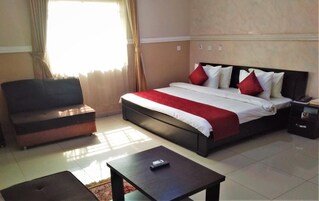 Una habitación de hotel con una cama, un sofá, una mesita y una mesita de noche.