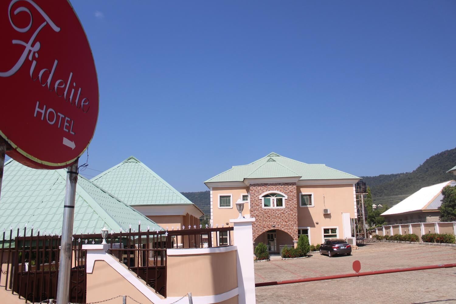 A hotel named 'Fidelite Hotel' with a brick facade, multiple windows, and a parking area.