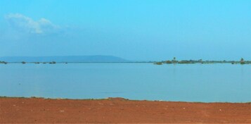 Una vasta extensión de agua con una tierra firme a lo lejos y cielo despejado.
