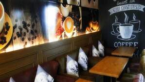 Een gezellig café interieur met houten tafels en zachte zitplaatsen.