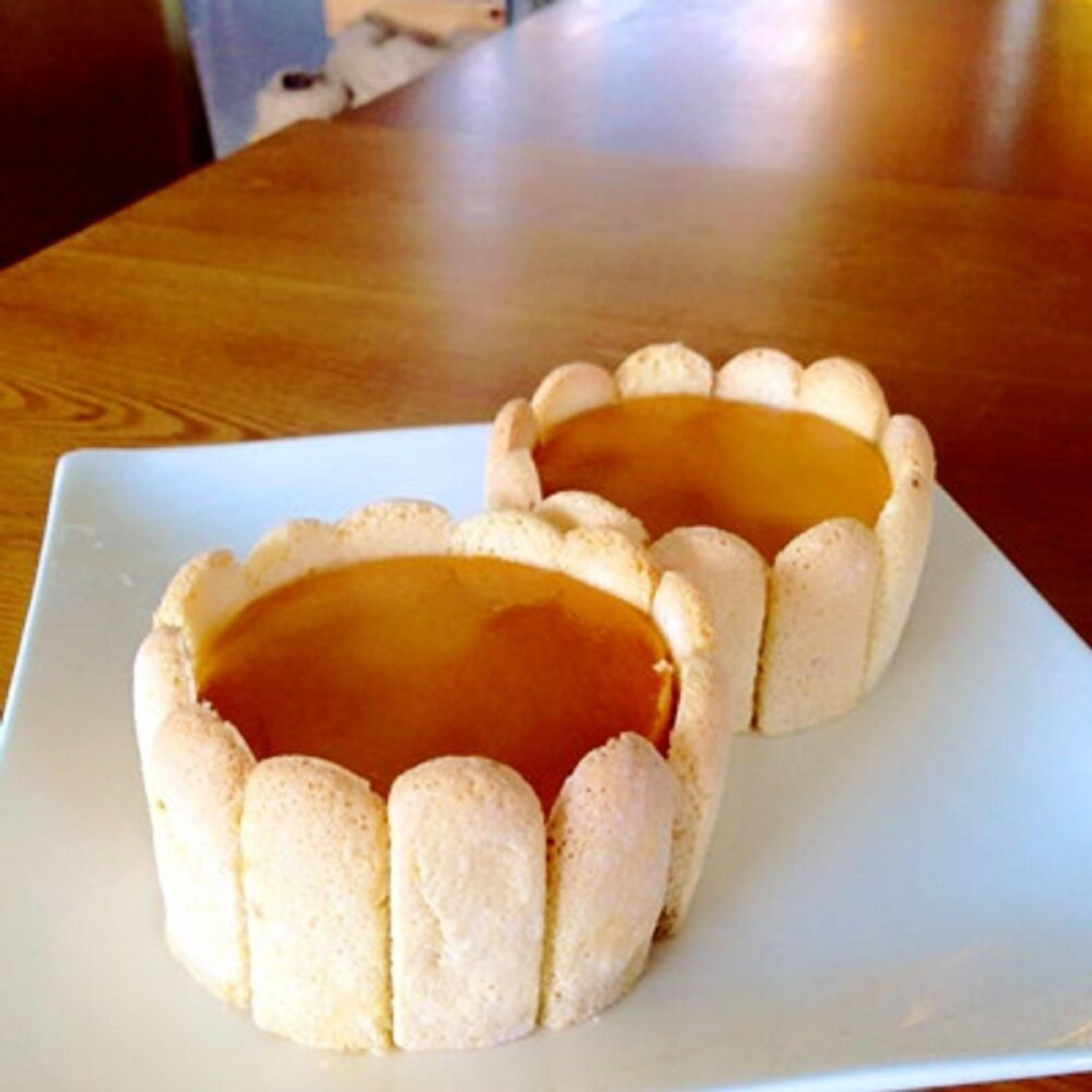 Two small, round, white desserts with a caramel-like filling on a white plate.