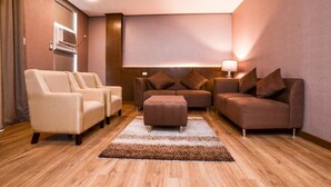 Een moderne woonkamer met een beige bank, een bruine bank en een bijpassend voetenbankje.