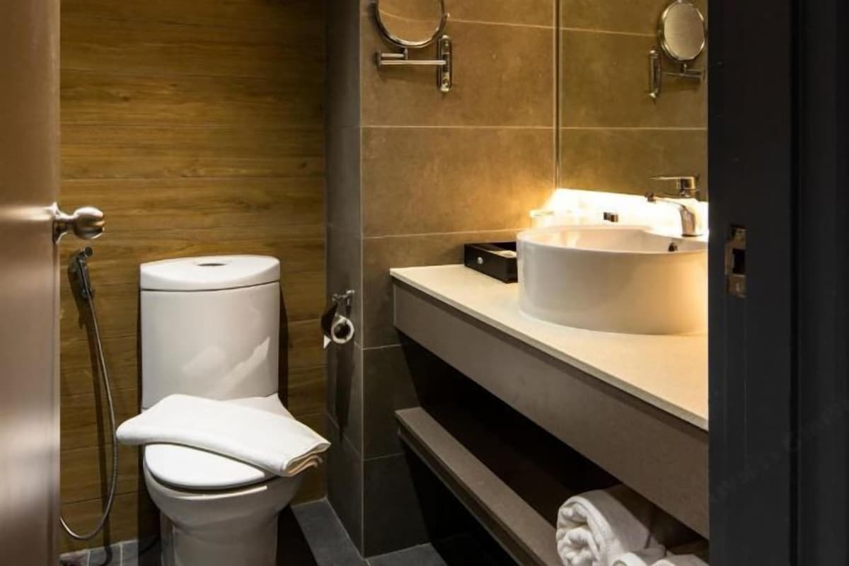 A modern bathroom with a toilet, bidet, and a sink with a mirror above it.