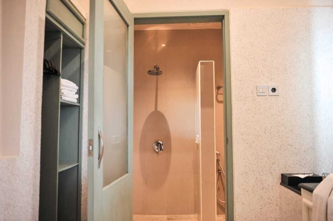 A bathroom with a shower, a towel rack, and a toilet.