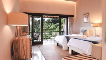 Een hotelkamer met balkon, een bed, bureau en stoel.