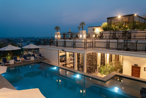 Piscine extérieure, parasols de plage, chaises longues