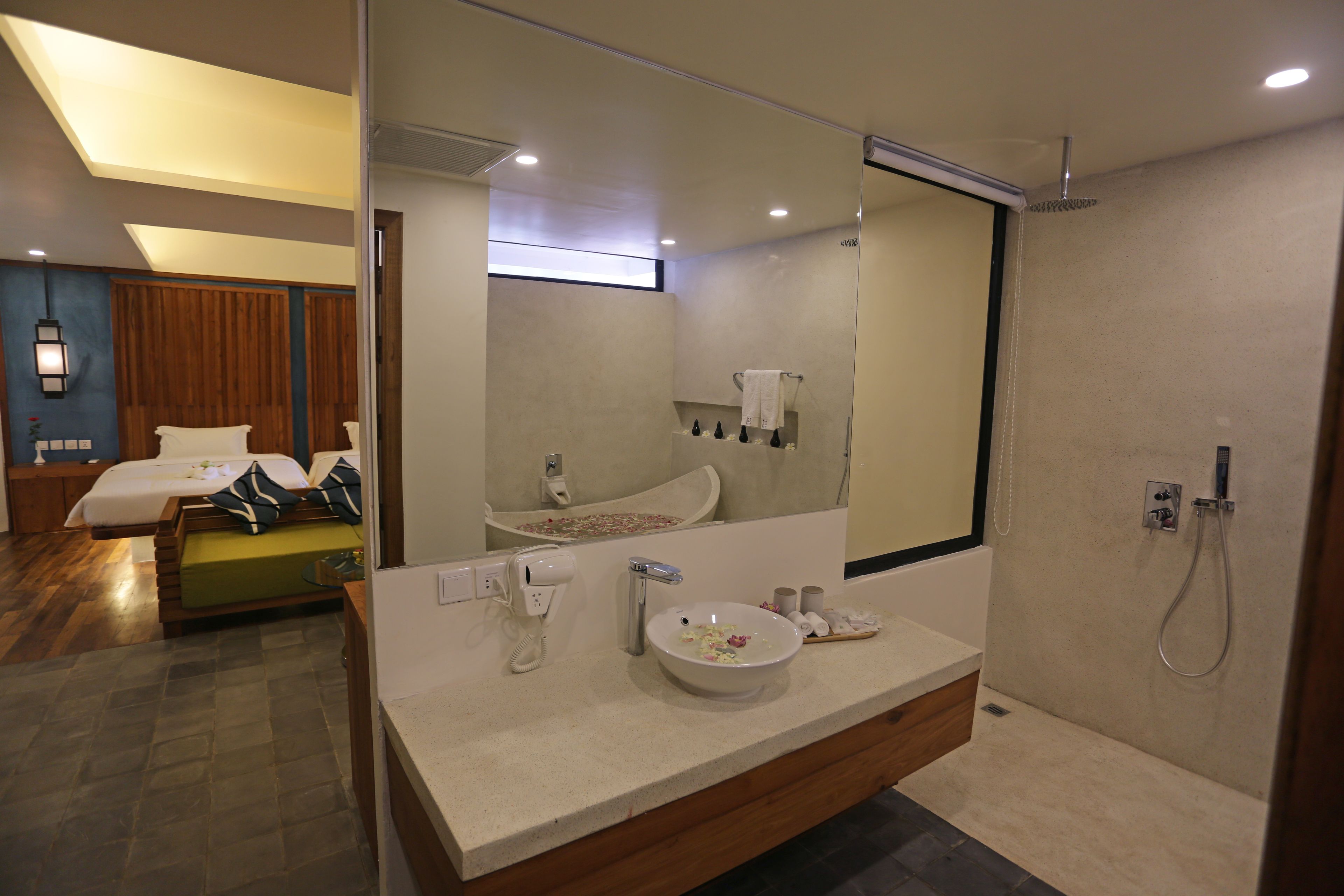 A modern bathroom with a large mirror, a sink, and a shower.