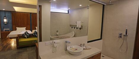 A modern bathroom with a large mirror, a sink, and a shower.