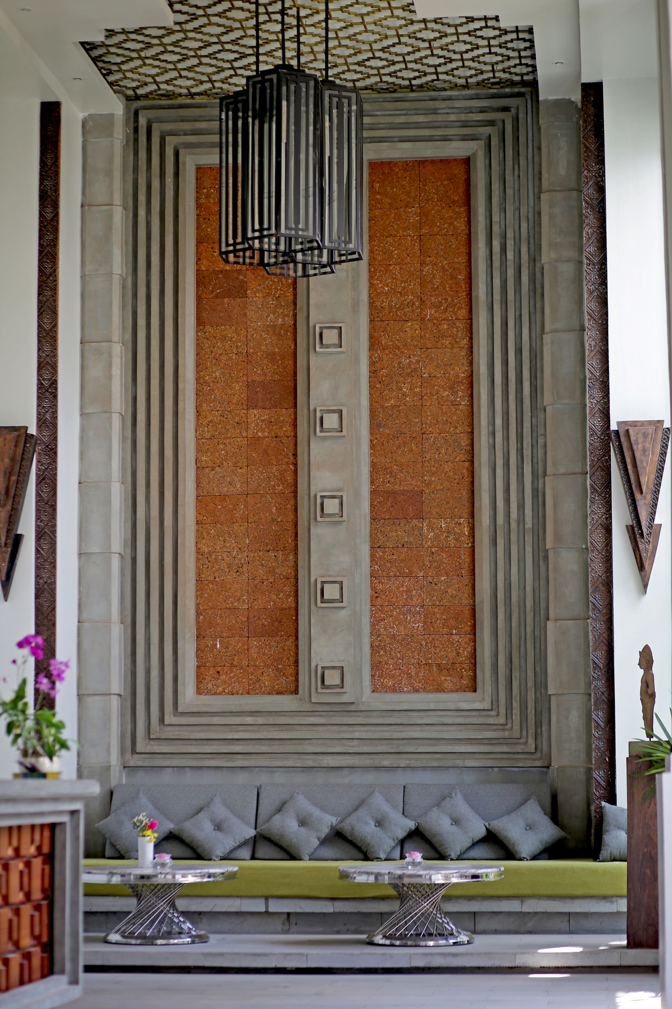 A lobby with a large seating area, a patterned ceiling, and a decorative wall.