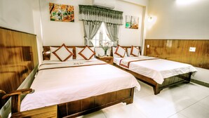A hotel room with two wooden beds, white linens, a window with curtains, and artwork on the walls. - Lucky Star hotel (Da Nang)