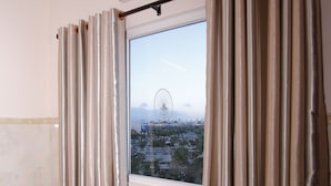 A room with a dining table and chairs, an air conditioning unit, and a window with curtains. - Lucky Star hotel (Da Nang)