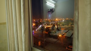 A view through a window of a cityscape at night, including a Ferris wheel and street lights. - Lucky Star hotel (Da Nang)