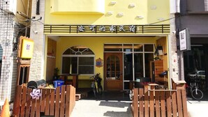 A yellow building with a sign reading "安可的家民宿". - ANKES Hostel (Hengchun)