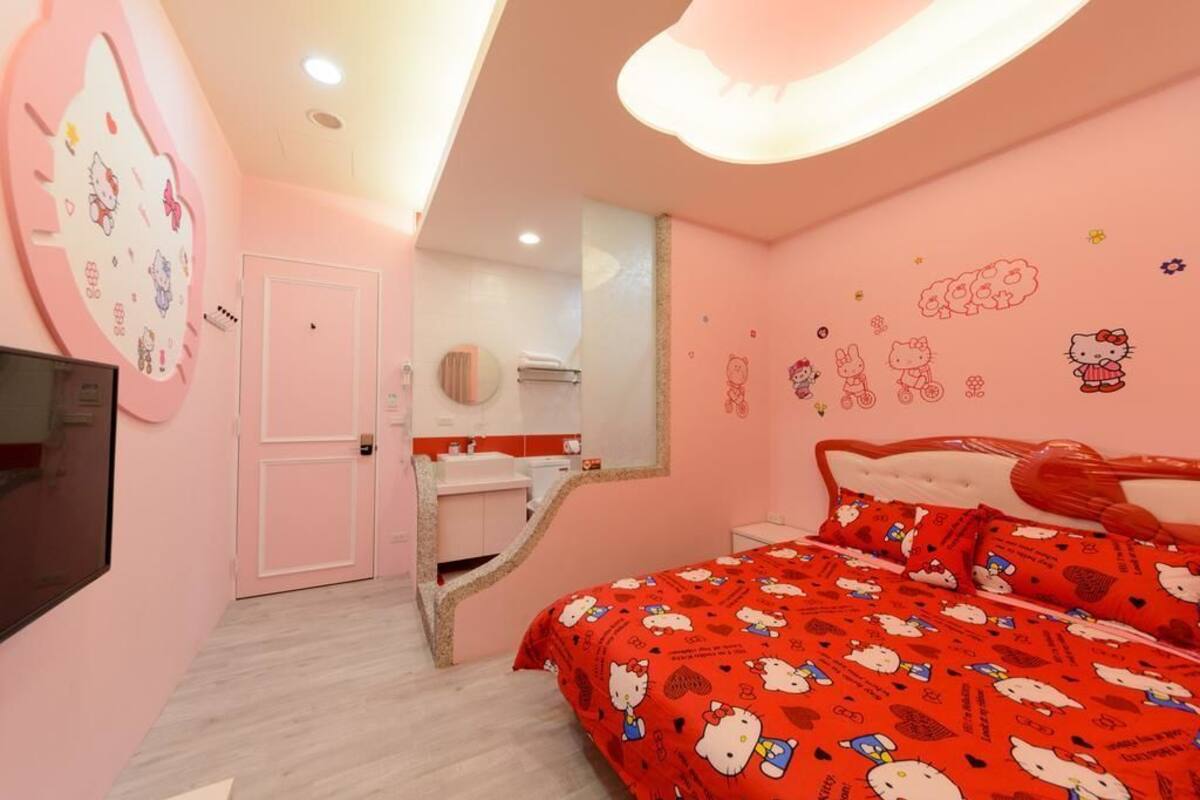 Un dormitorio con decoración rosa, que incluye una cama, un espejo, una tocador y una puerta.
