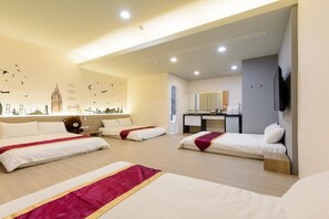 A hotel room with three beds, a desk, a mirror, and a TV. - ANKES Hostel (Hengchun)