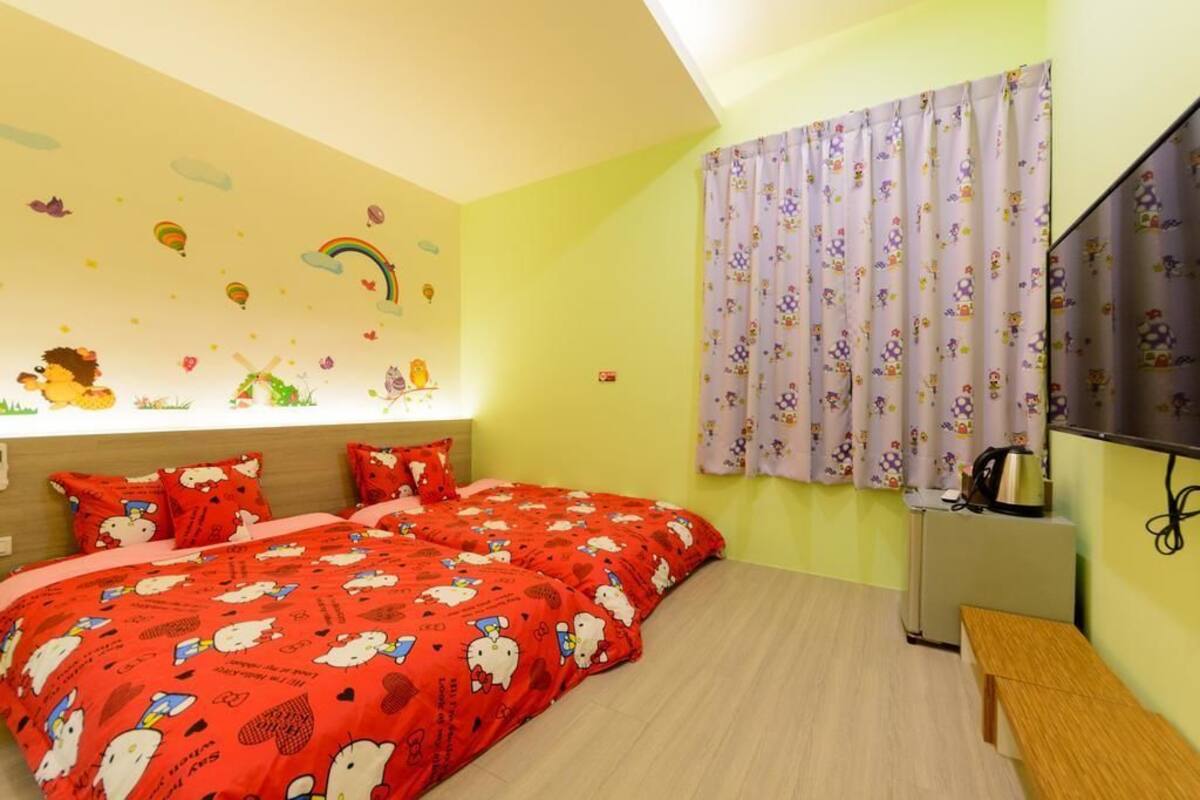 Un dormitorio con cama, escritorio y televisor.