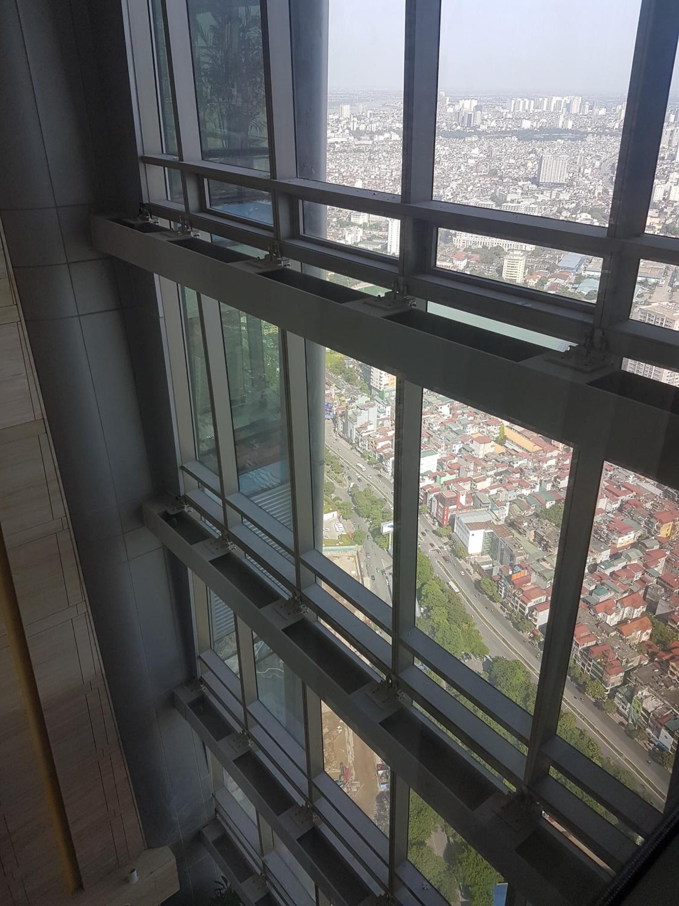 A high-rise building with multiple windows offering a view of a cityscape.
