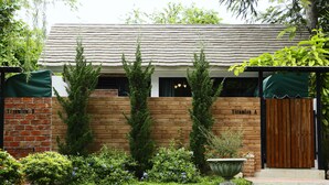 A brick building with a wooden facade, a wooden door, and a green awning. - Ginger Bread House - Pet Lover Resort (Nakhon Nayok)