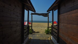 A wooden beach entrance with a sign reading "Florida Paradise" leading to a sandy beach with umbrellas. - Agonda Paradise (Canacona)