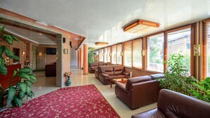 A spacious lobby with a red carpet, leather sofas, and large windows with blinds. - Hotel Royal Beach (Varna)