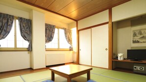 A traditional Japanese room with tatami flooring, a low wooden table, and two cushions. - Hakuba Tsugaike Sunrise TANNE (Otari)