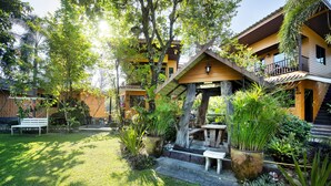 A courtyard with a wooden gazebo, potted plants, and a bench. - Greenview Resort (Nakhon Nayok)