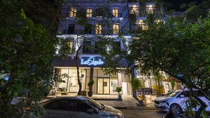 A hotel with a modern facade, multiple balconies, and a visible storefront named "La Cigale." - La Cigale Residence (Ho Chi Minh City)