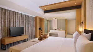 Une chambre d’hôtel moderne équipée d’un grand lit, d’une télévision, d’un bureau et d’une salle de bain.