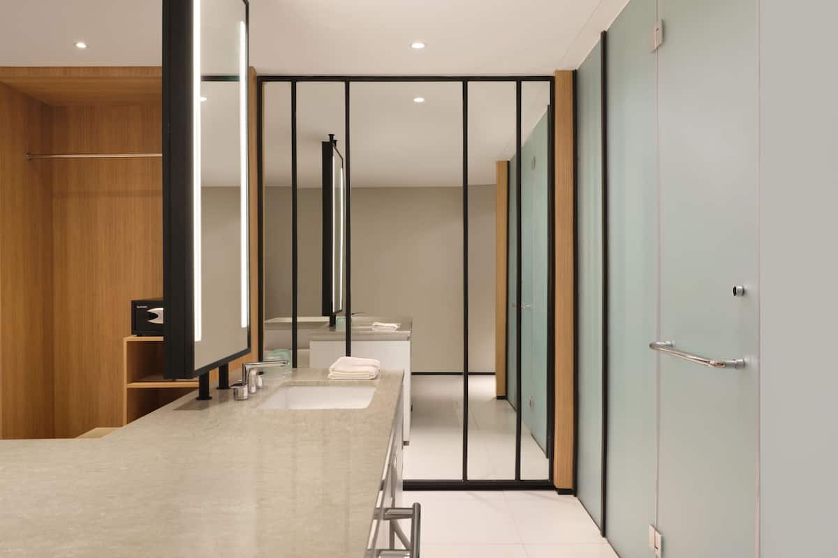Een moderne badkamer met een grote spiegel, een wastafel en een toilet.