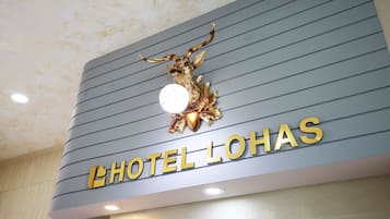 A hotel sign with a golden deer emblem and the name "HOTEL LOHAS".