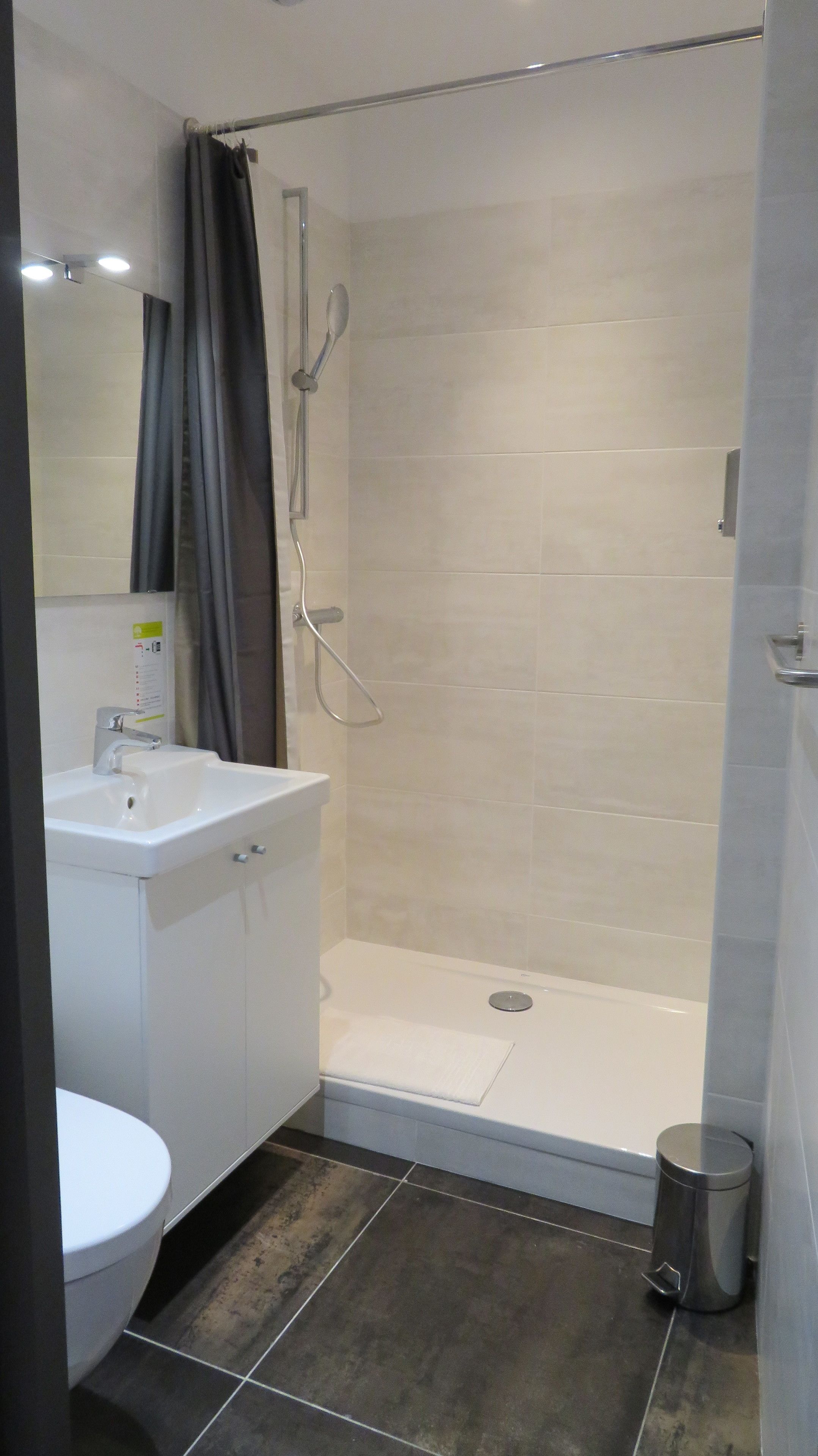 Un bagno moderno dotato di doccia, lavabo e WC.