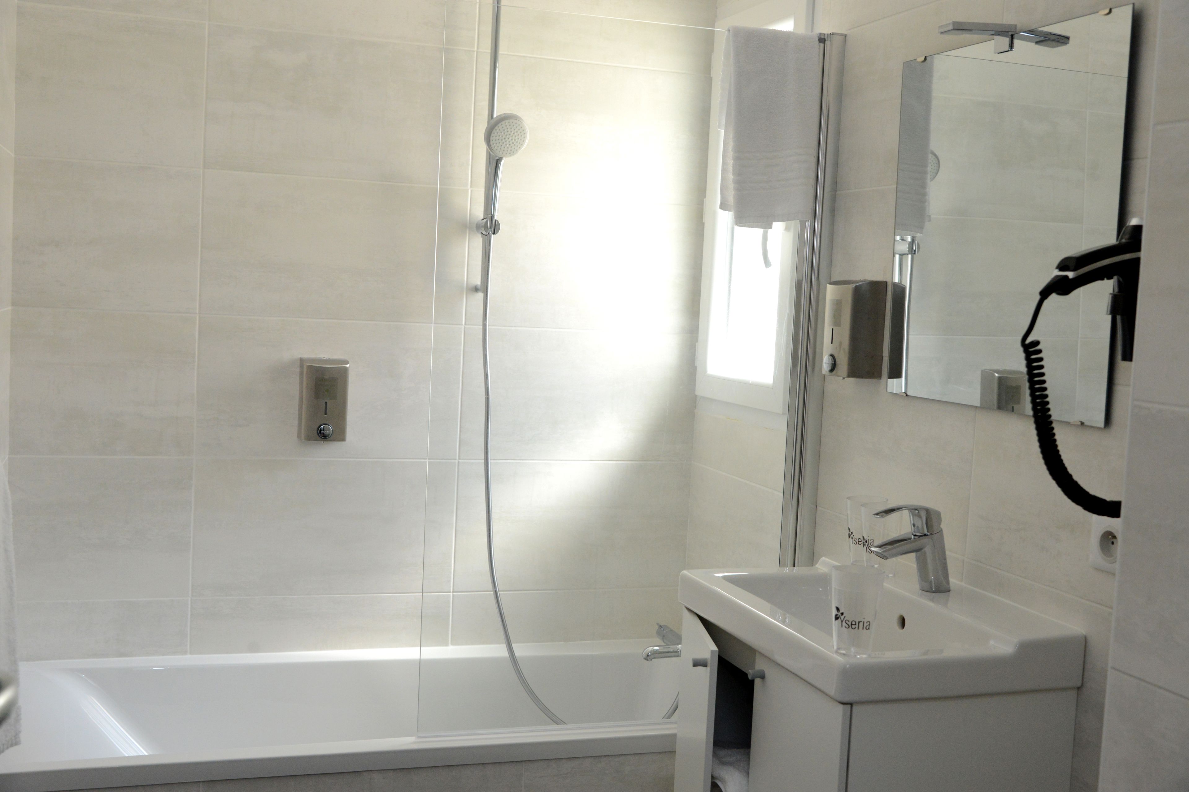 A modern bathroom with a bathtub, a shower, and a sink with a mirror.