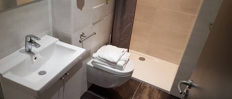 Un baño con lavabo, inodoro y ducha.