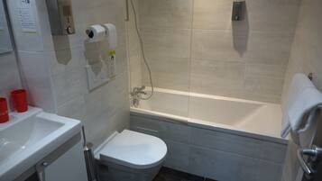 A bathroom with a toilet, sink, and bathtub.