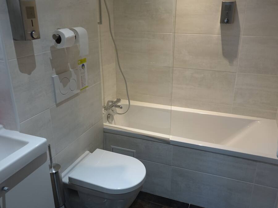 A bathroom with a toilet, sink, and bathtub.